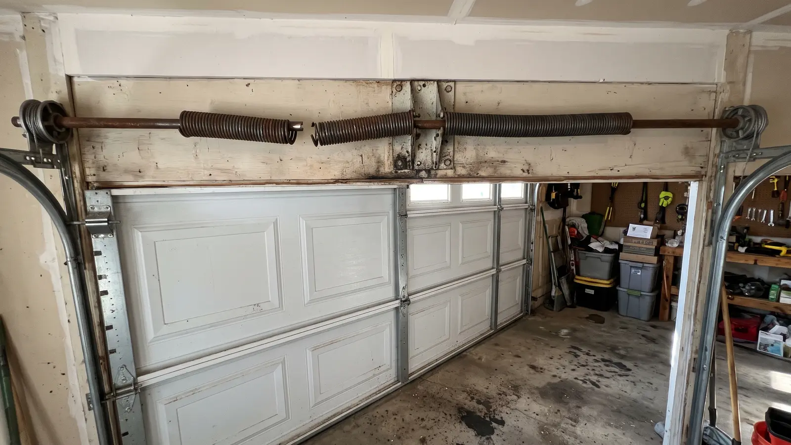 Broken torsion spring with a visible gap above a garage door in a Wichita home